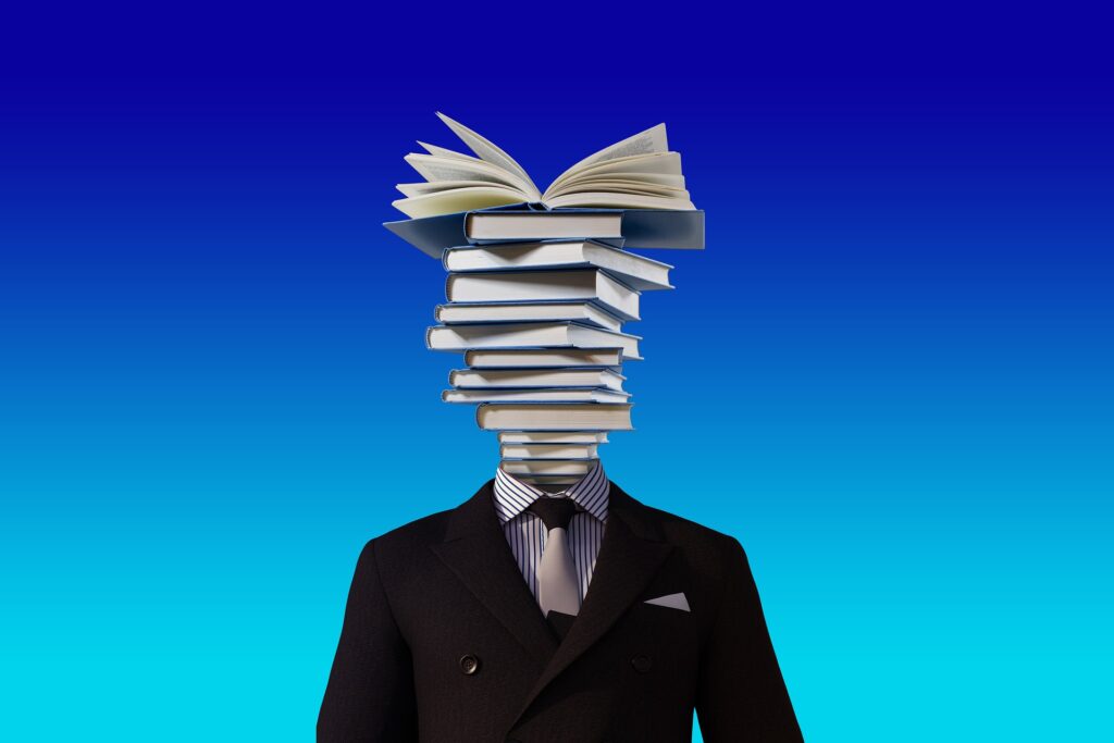 This is a decorative image representing a teacher with books instead of the head